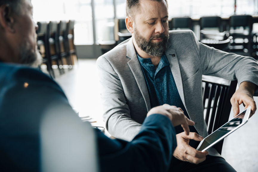 Businessmen talking, working with digital tablet in cafe